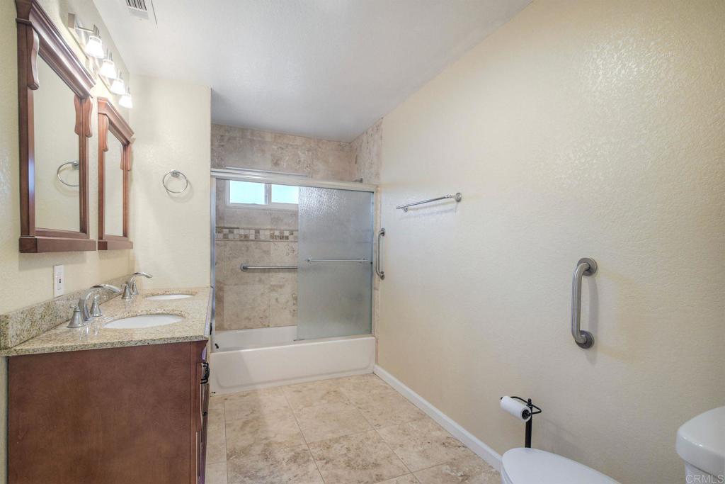 769 Magnolia Avenue, Unit B Carlsbad, CA 92008 - Photo 14 of 25 a bathroom with a granite countertop sink a toilet and shower