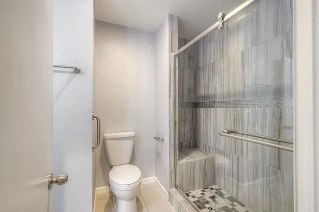 a bathroom with a toilet and a shower