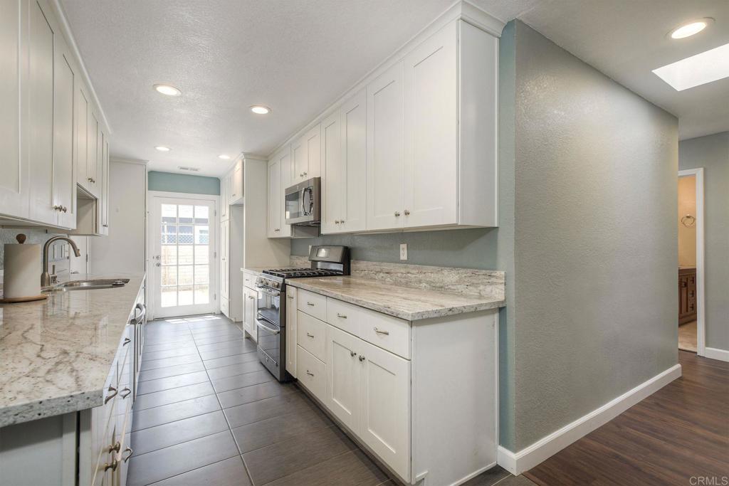 769 Magnolia Avenue, Unit B Carlsbad, CA 92008 - Photo 8 of 25 a kitchen with a sink stove and cabinets