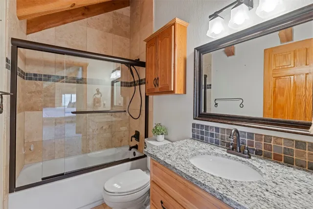 a bathroom with a granite countertop sink toilet and shower
