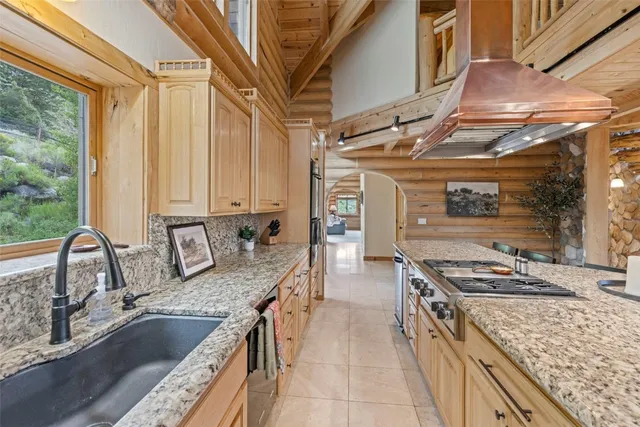 a kitchen with stainless steel appliances granite countertop a sink stove and cabinets