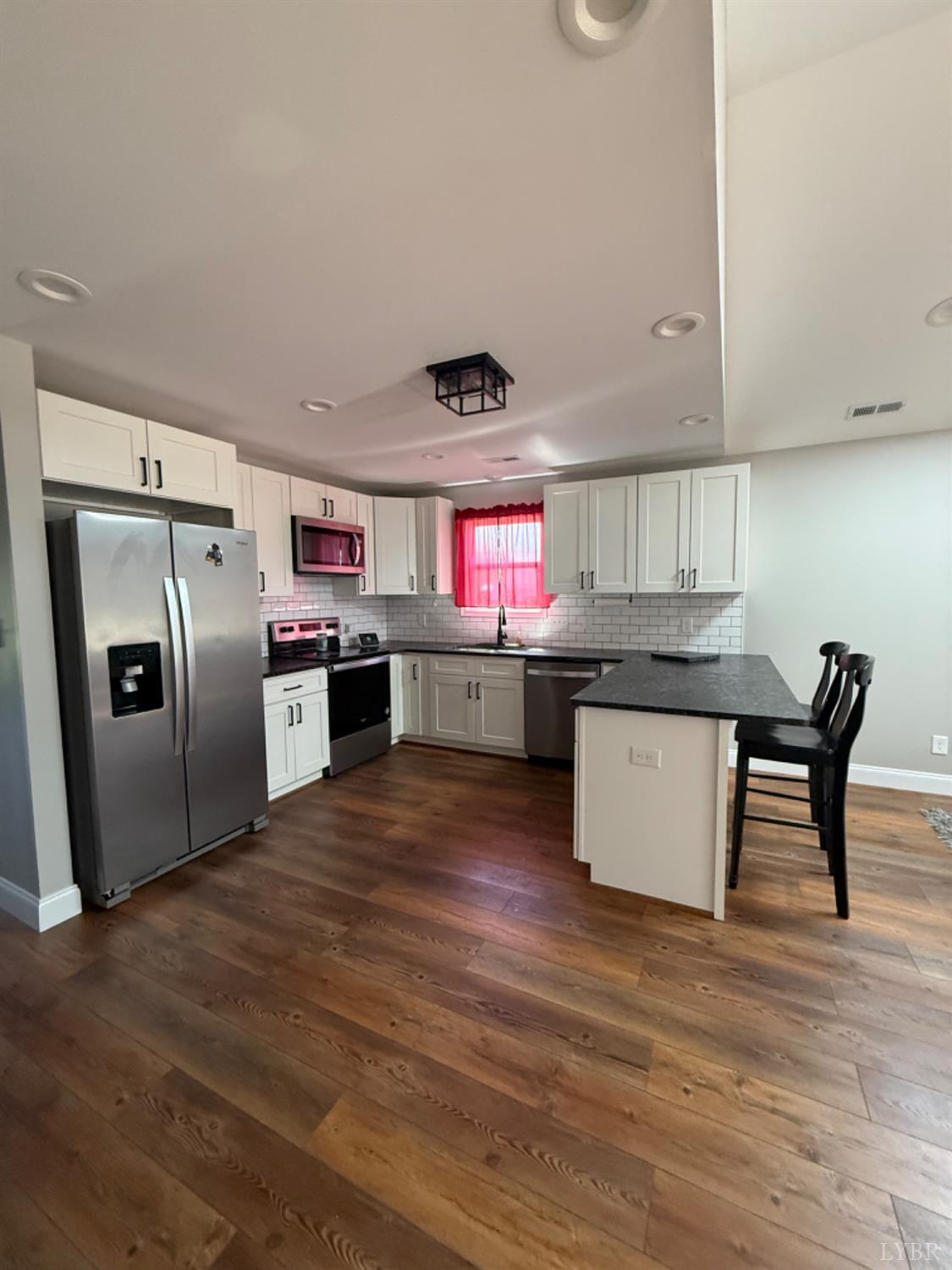 129 Ned Brown Road Amherst, VA 24521 - Photo 11 of 30 a kitchen with stainless steel appliances granite countertop a refrigerator a stove and a wooden floors