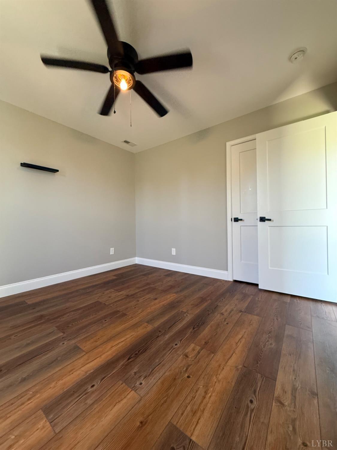 129 Ned Brown Road Amherst, VA 24521 - Photo 23 of 30 wooden floor in an empty room with a ceiling fan