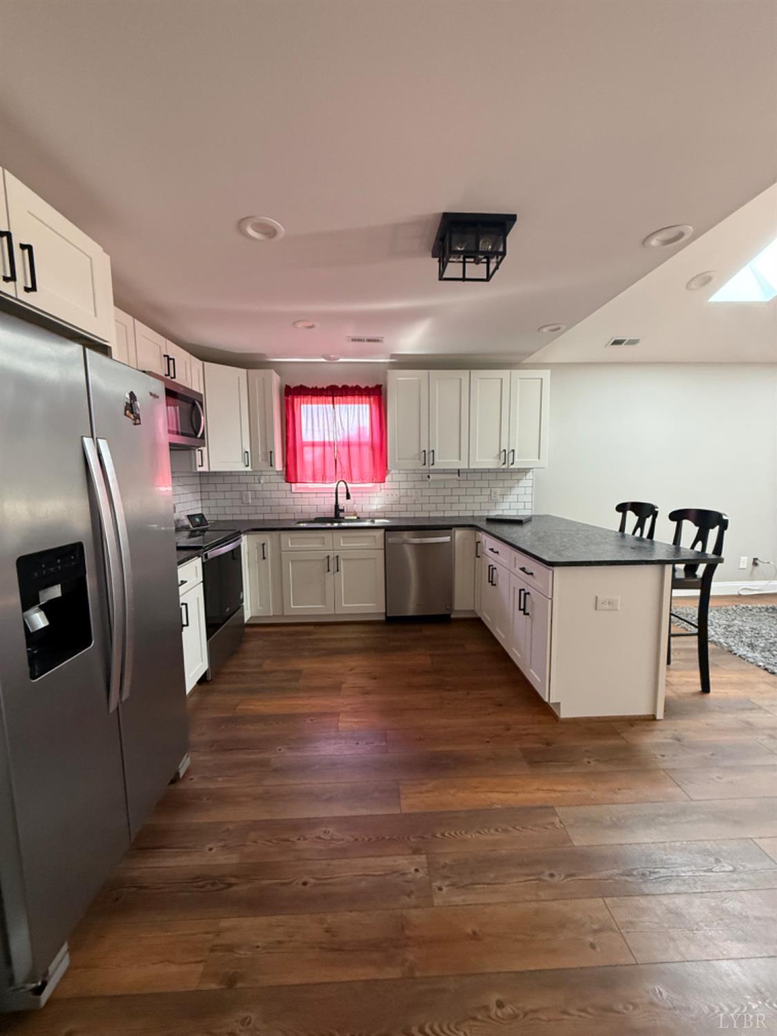 129 Ned Brown Road Amherst, VA 24521 - Photo 10 of 30 a kitchen with stainless steel appliances granite countertop a refrigerator a stove and a wooden floors