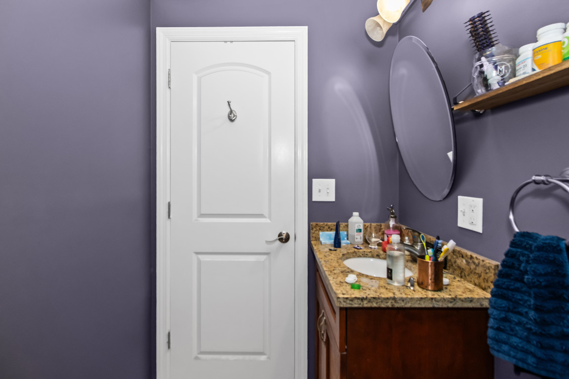 2710 North Artesian Avenue Chicago, IL 60647 - Photo 11 of 61 a bathroom with a granite countertop sink and a mirror