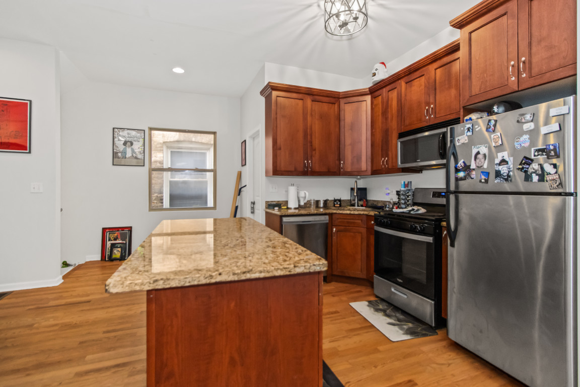 2710 North Artesian Avenue Chicago, IL 60647 - Photo 21 of 61 a kitchen with stainless steel appliances granite countertop a stove a sink dishwasher and a refrigerator with wooden cabinets