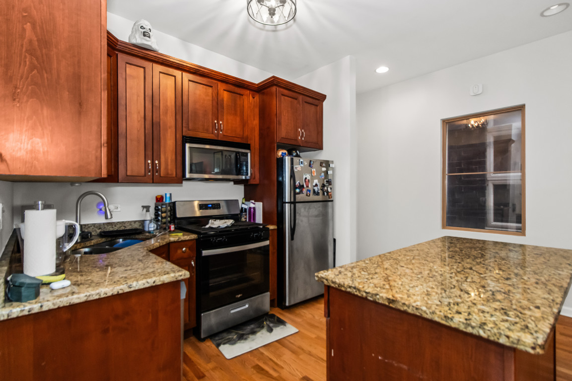 2710 North Artesian Avenue Chicago, IL 60647 - Photo 23 of 61 a kitchen with stainless steel appliances granite countertop a stove refrigerator and microwave