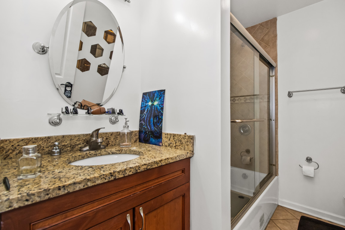 2710 North Artesian Avenue Chicago, IL 60647 - Photo 24 of 61 a bathroom with a granite countertop sink and a mirror