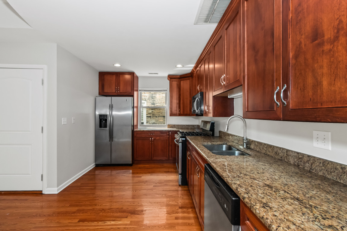 2710 North Artesian Avenue Chicago, IL 60647 - Photo 33 of 61 a kitchen with stainless steel appliances granite countertop a sink a stove and a refrigerator