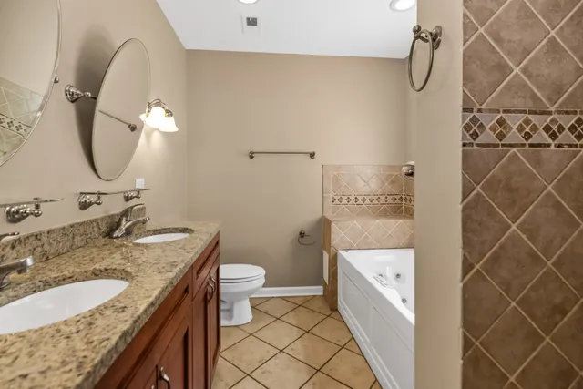 a bathroom with a granite countertop sink a toilet and shower
