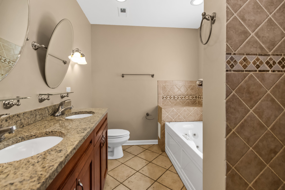 2710 North Artesian Avenue Chicago, IL 60647 - Photo 35 of 61 a bathroom with a granite countertop sink a toilet and a mirror
