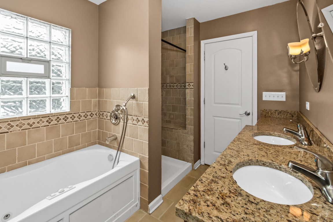 2710 North Artesian Avenue Chicago, IL 60647 - Photo 36 of 61 a bathroom with a granite countertop tub sink and mirror