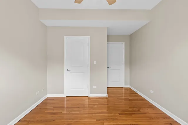 a view of kitchen and empty room with wooden floor