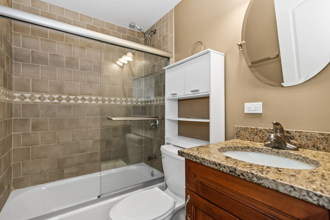 2710 North Artesian Avenue Chicago, IL 60647 - Photo 41 of 61 a bathroom with a granite countertop sink a toilet and shower
