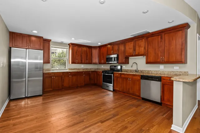 a bathroom with a granite countertop sink a toilet and shower