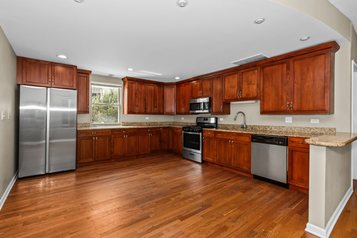 2710 North Artesian Avenue Chicago, IL 60647 - Photo 48 of 61 a kitchen with stainless steel appliances granite countertop a refrigerator sink and cabinets