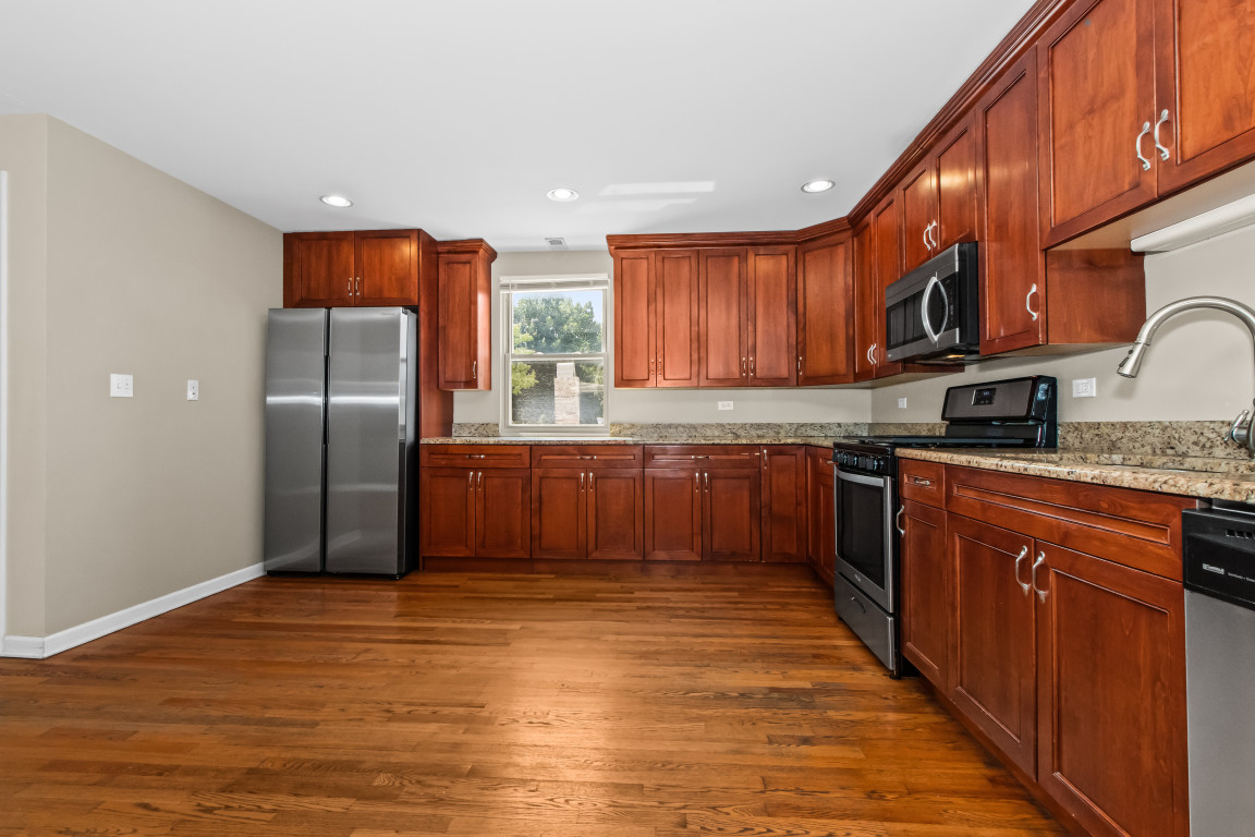 2710 North Artesian Avenue Chicago, IL 60647 - Photo 49 of 61 a kitchen with stainless steel appliances granite countertop a stove a sink dishwasher a refrigerator and cabinets with wooden floor