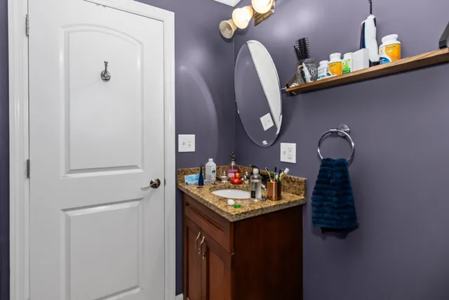a bathroom with a granite countertop sink and a mirror