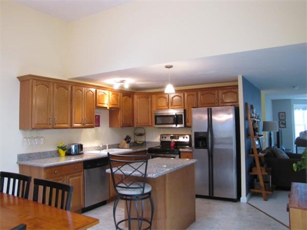 9 Pearlbush Path Worcester, MA 01607 - Photo 3 of 28 a kitchen with stainless steel appliances granite countertop a refrigerator a sink a stove a dining table and chairs