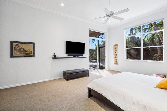 a bedroom with a bed window and flat screen tv