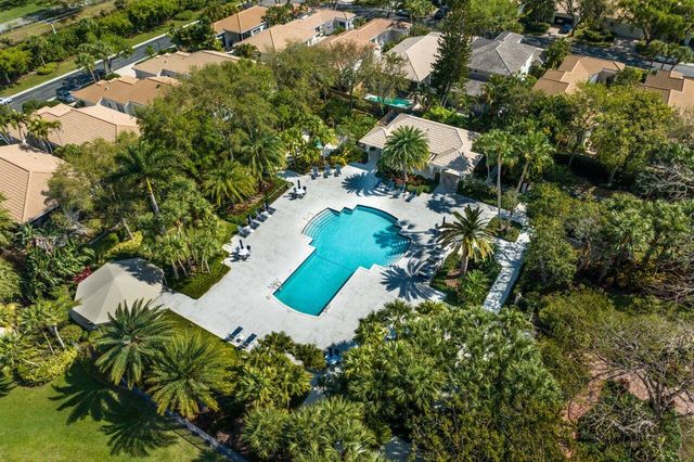 an aerial view of a house with a yard and large trees