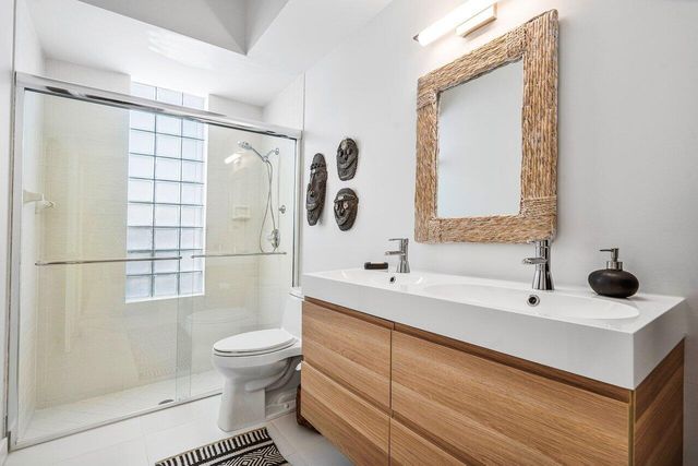 a bathroom with a sink a toilet and shower