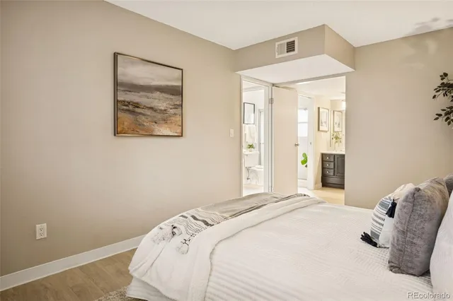 a bedroom with a bed and a painting on the wall