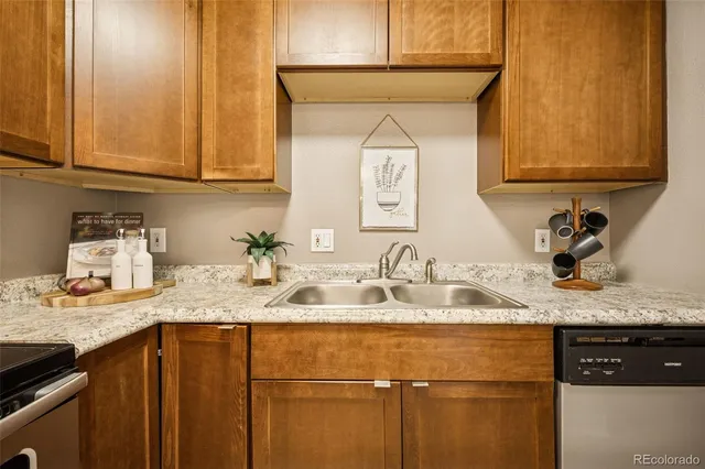 a kitchen with granite countertop a sink stainless steel appliances and cabinets