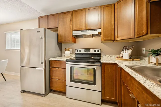 a kitchen with appliances a refrigerator and a sink
