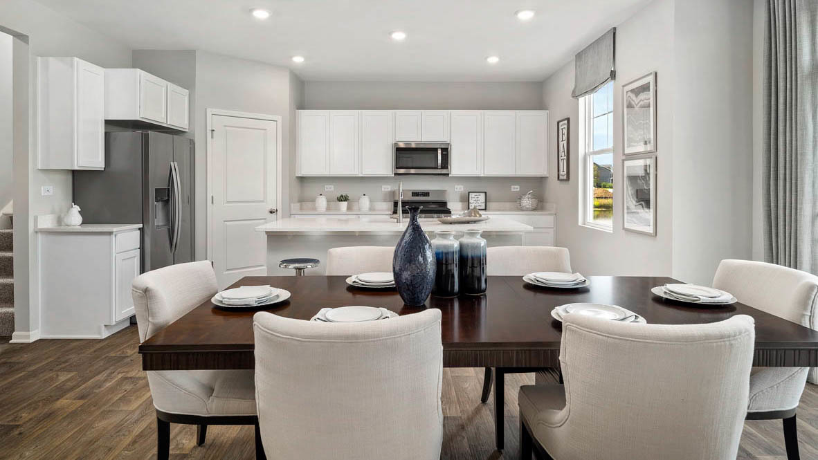 1810 Legacy Pointe Boulevard Plainfield, IL 60586 - Photo 9 of 20 a kitchen with a dining table chairs and refrigerator