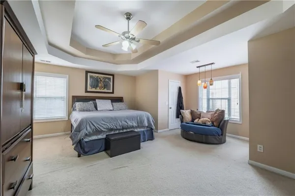 a spacious bedroom with a bed and ceiling fan