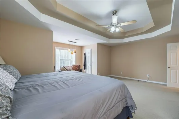 a bedroom with a large bed and a chandelier