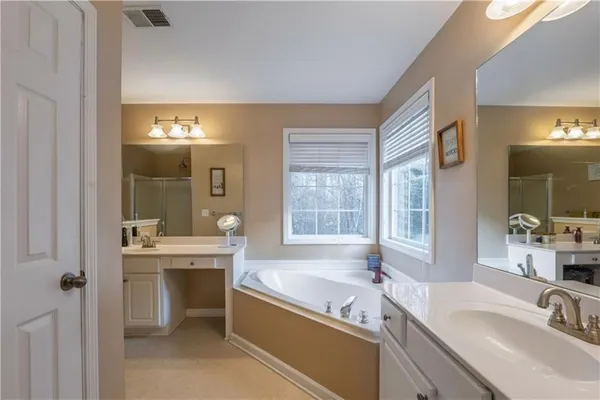 a bathroom with a tub sink and mirror