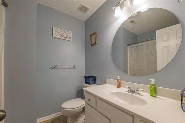 a bathroom with a sink a toilet and a mirror