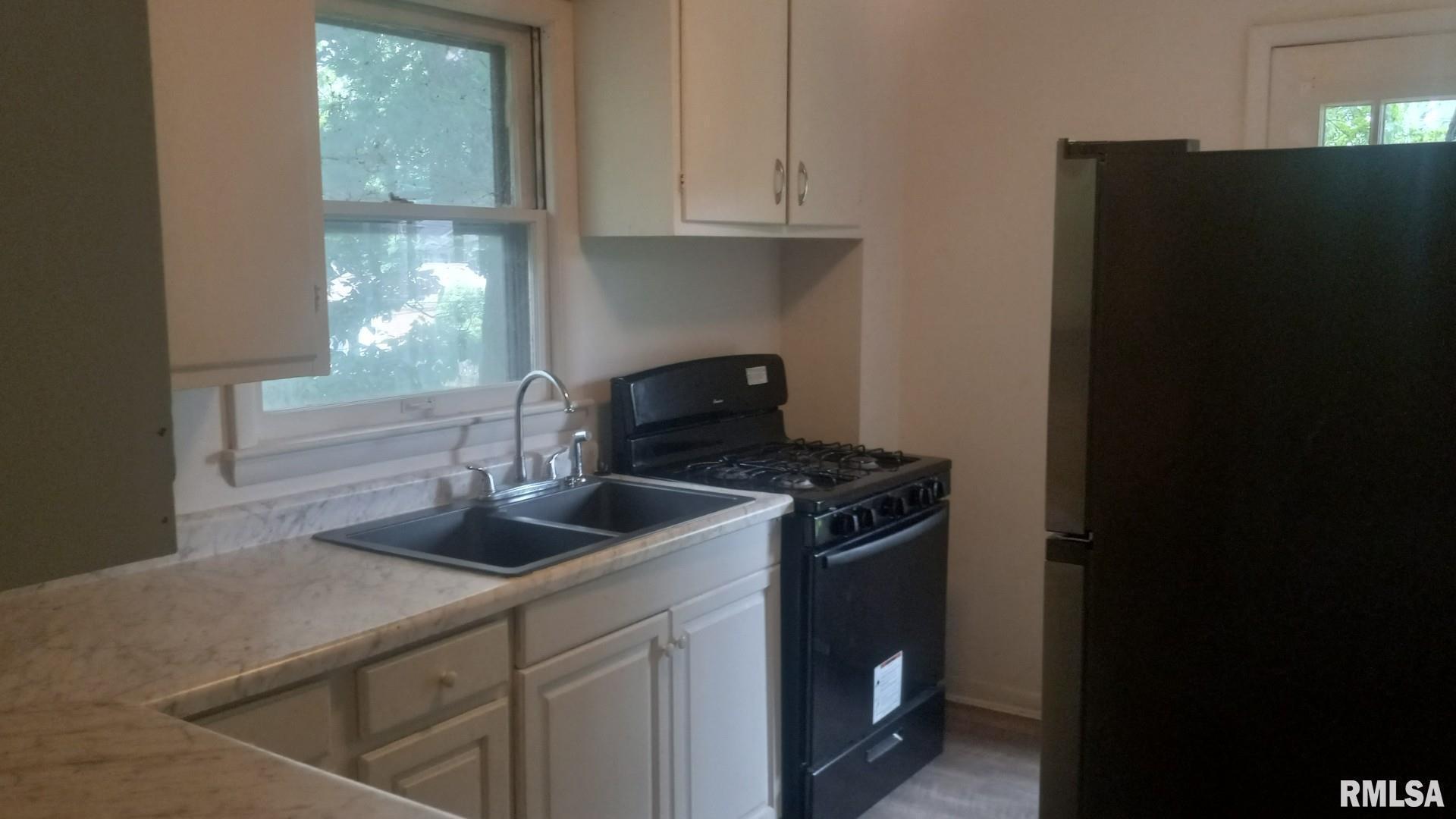 735 20th Avenue, Unit 8 East Moline, IL 61244 - Photo 4 of 5 a kitchen with granite countertop a refrigerator stove and sink