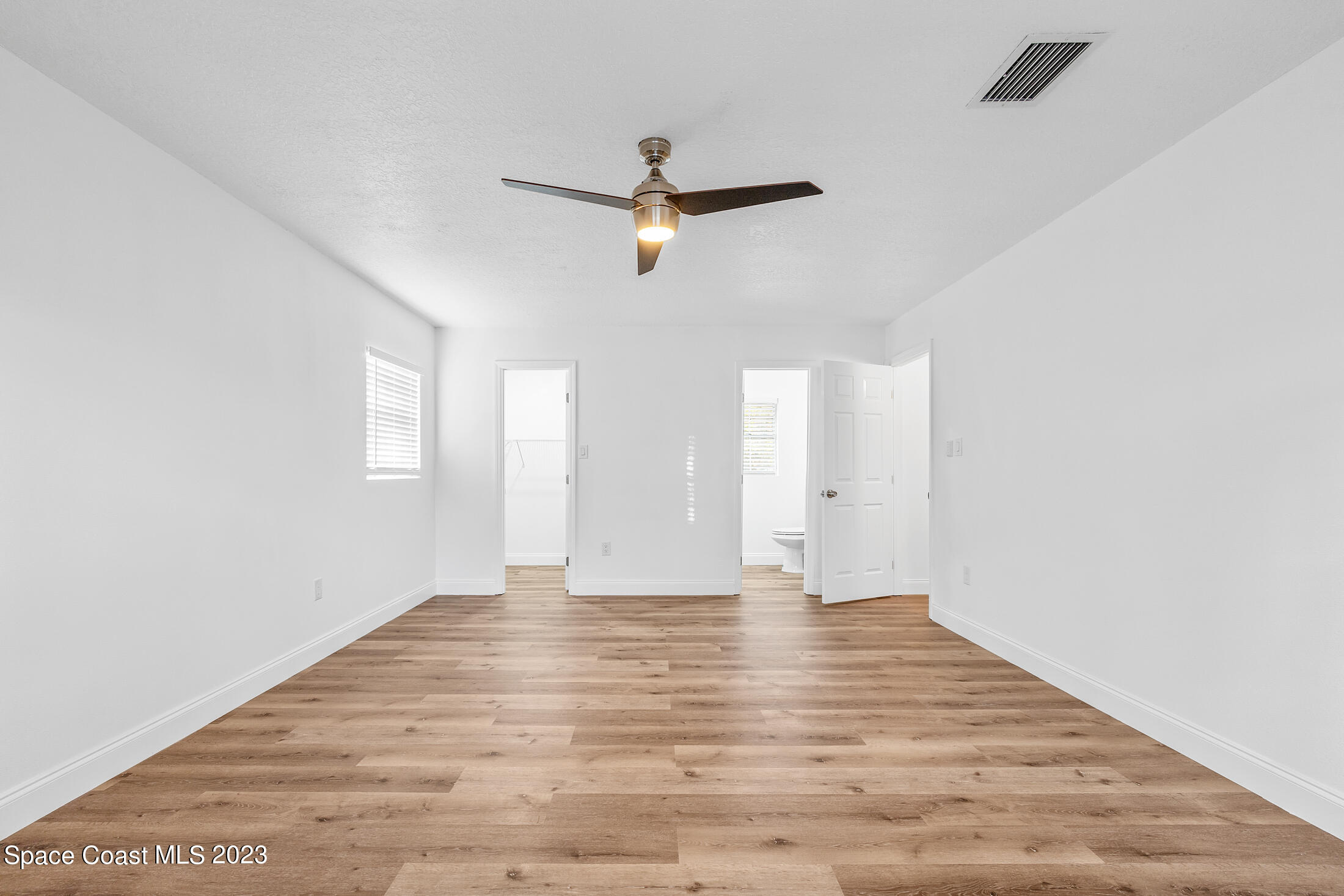 2300 Cox Road Cocoa, FL 32926 - Photo 18 of 41 a view of empty room with wooden floor and fan
