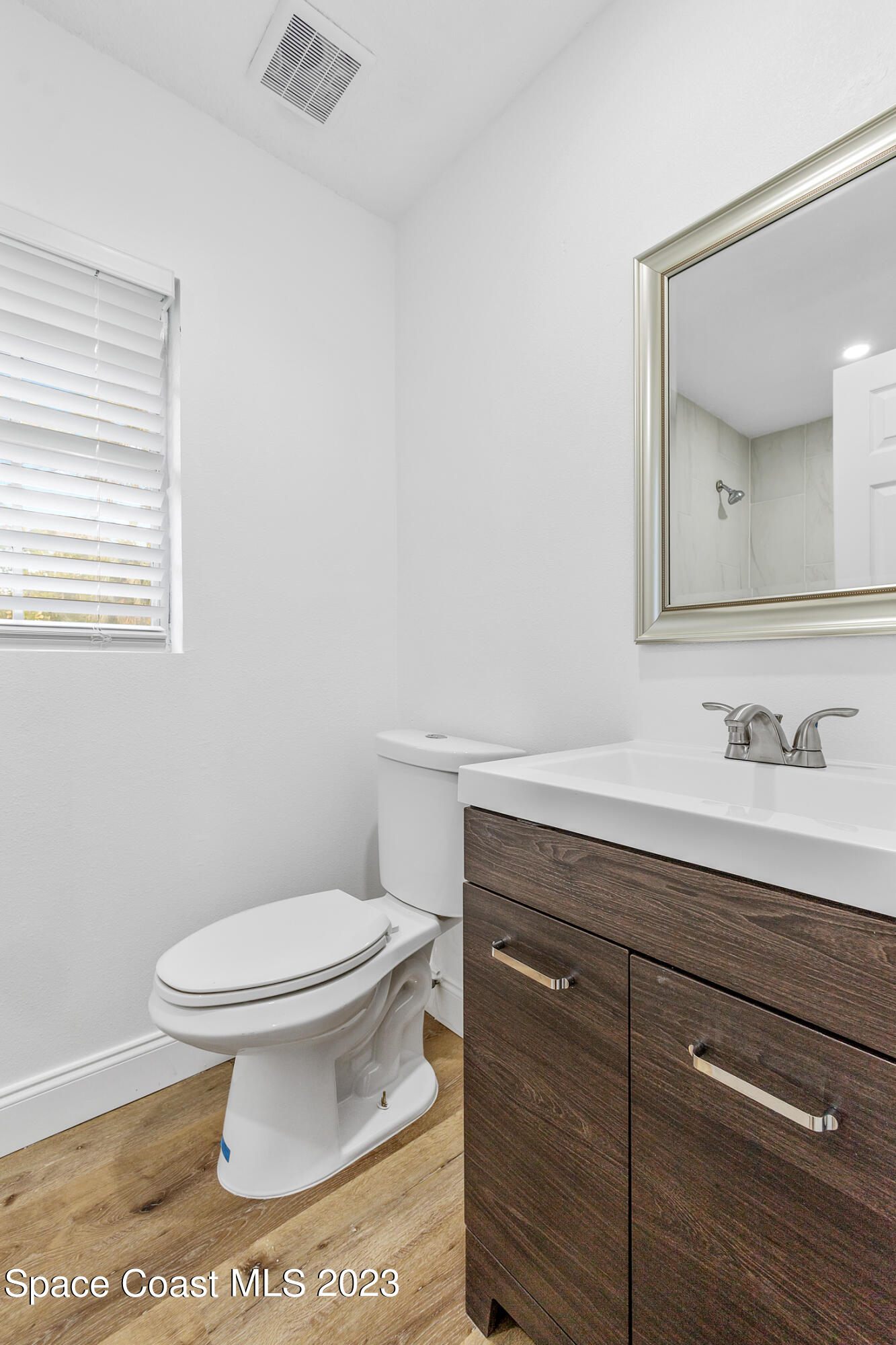 2300 Cox Road Cocoa, FL 32926 - Photo 19 of 41 a bathroom with a granite countertop toilet sink and mirror
