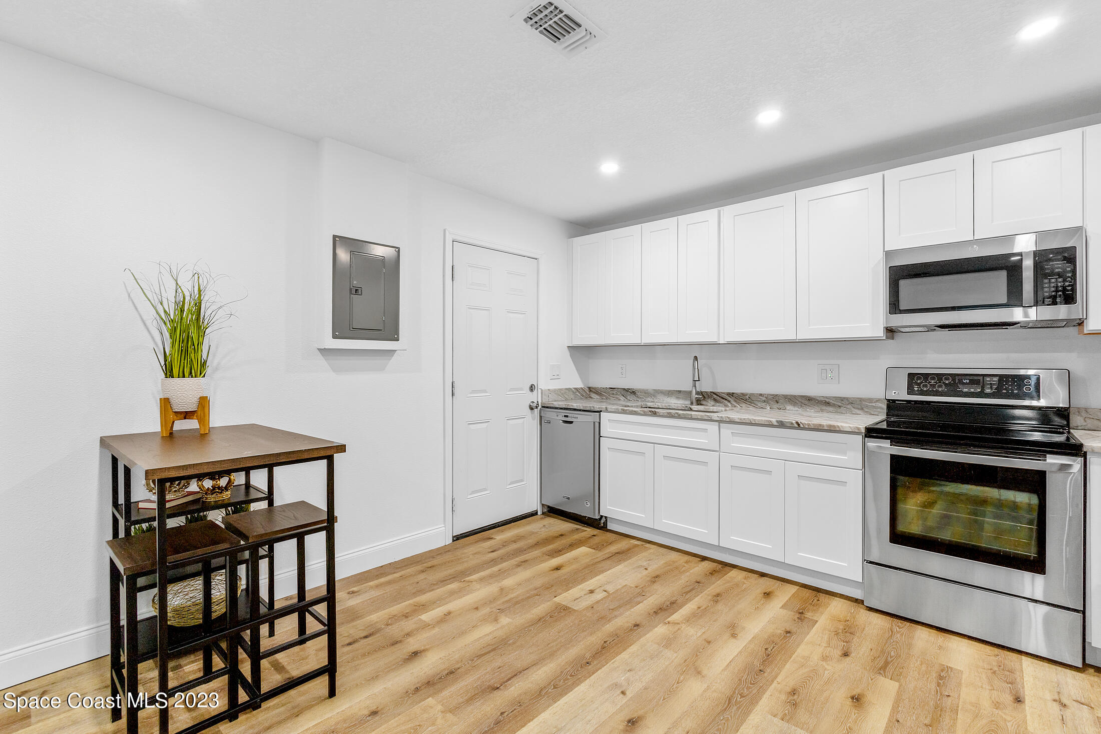 2300 Cox Road Cocoa, FL 32926 - Photo 25 of 41 a kitchen with granite countertop a stove a sink and a microwave