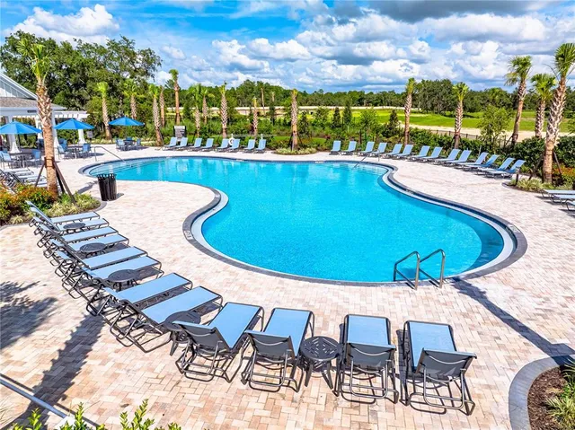 an aerial view of a swimming pool patio and outdoor seating