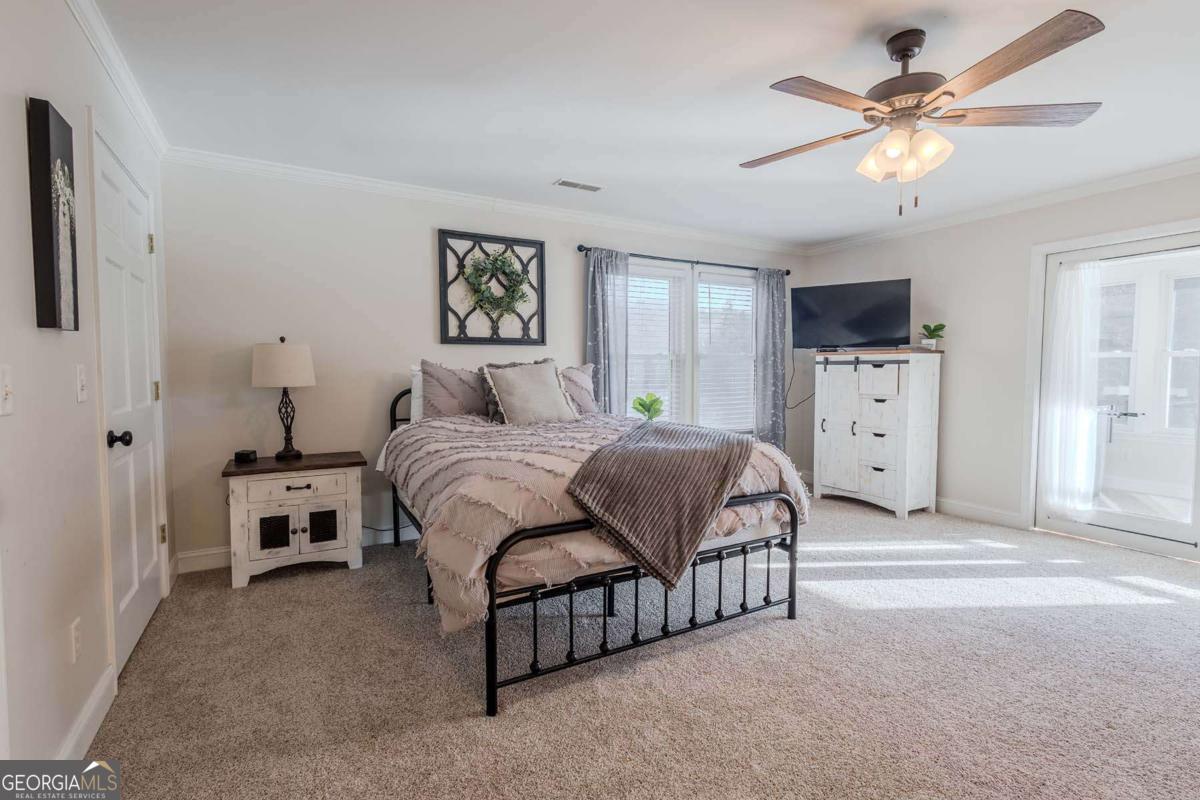 53 Addle Trail, Unit 2382 Ellijay, GA 30540 - Photo 23 of 42 a bedroom with a white bed and a chandelier