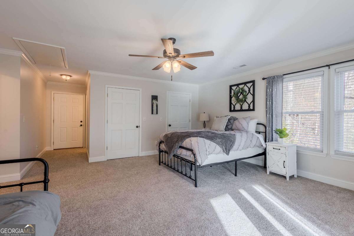 53 Addle Trail, Unit 2382 Ellijay, GA 30540 - Photo 25 of 42 a spacious bedroom with a bed a chandelier and windows