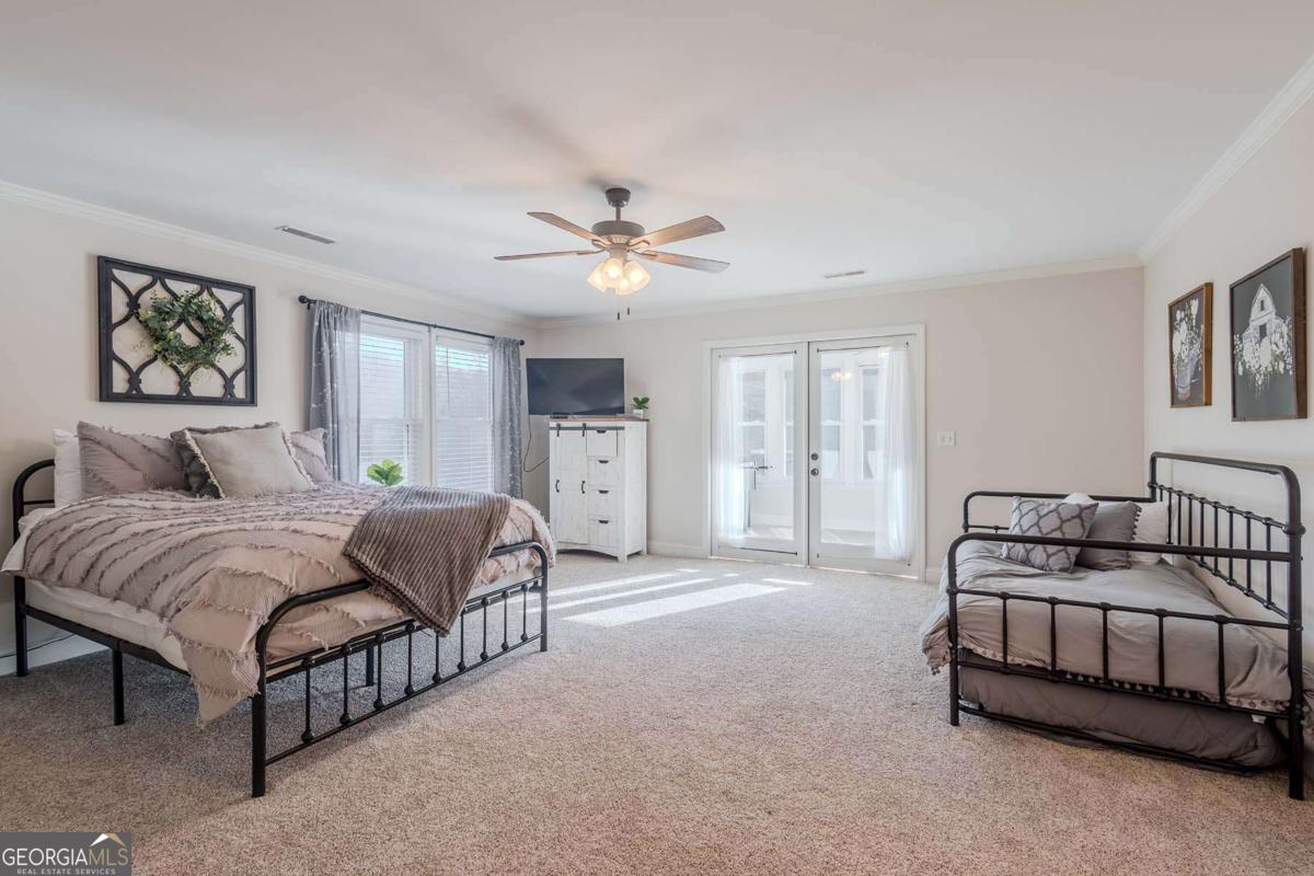 53 Addle Trail, Unit 2382 Ellijay, GA 30540 - Photo 26 of 42 a spacious bedroom with a bed a couch and a chandelier