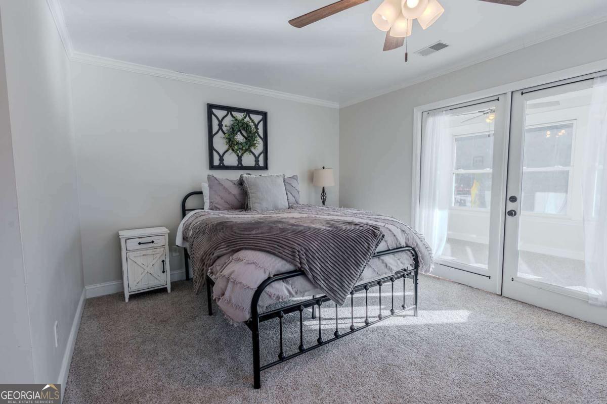 53 Addle Trail, Unit 2382 Ellijay, GA 30540 - Photo 29 of 42 a bedroom with a bed and a chandelier