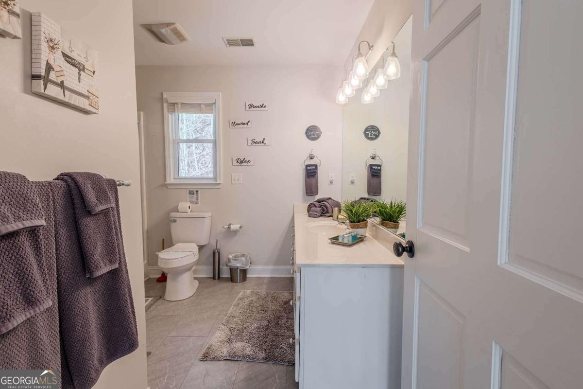 53 Addle Trail, Unit 2382 Ellijay, GA 30540 - Photo 32 of 42 a bathroom with a toilet sink and mirror