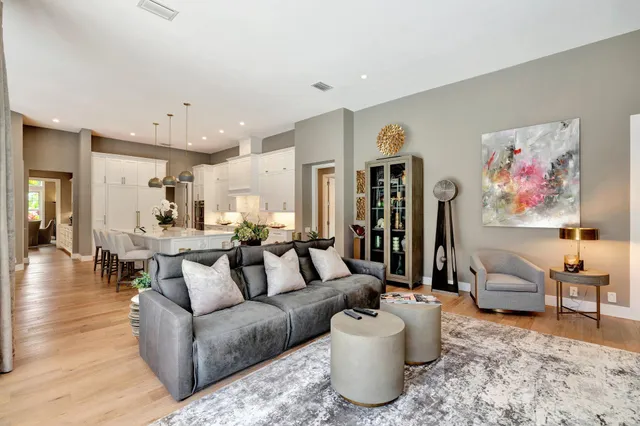 a view of an empty room with wooden floor and a ceiling fan
