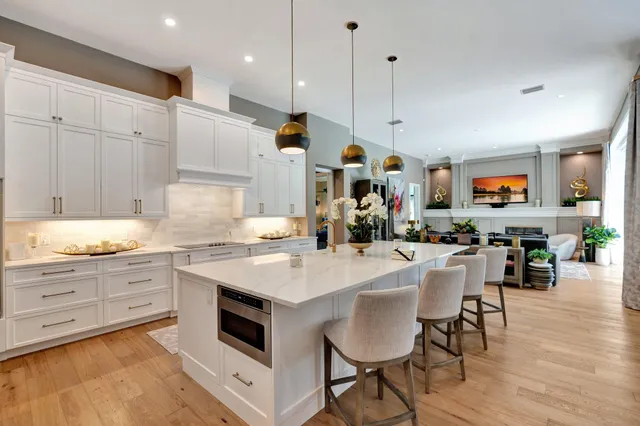 a room with stainless steel appliances kitchen island granite countertop furniture and a wooden floor