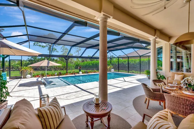 a view of a patio with a table chairs and a small yard