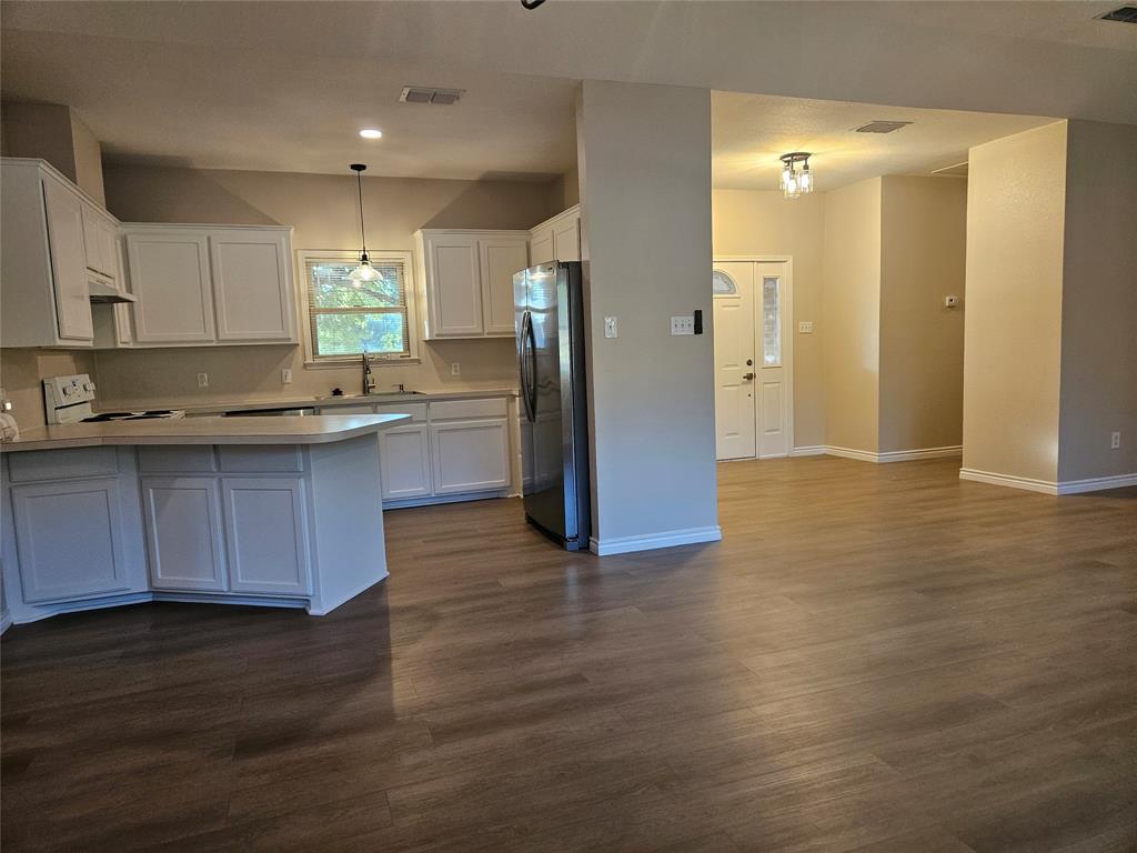 204 West Rentz Street Weatherford, TX 76086 - Photo 4 of 32 Spacious kitchen featuring white cabinetry, light-toned countertops, and stainless steel appliances