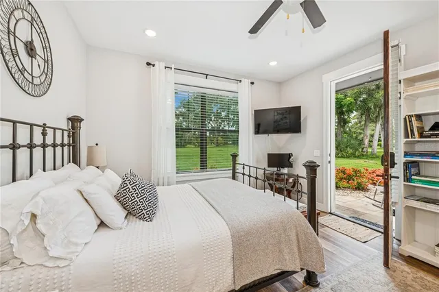 a bedroom with a bed a window and a flat screen tv
