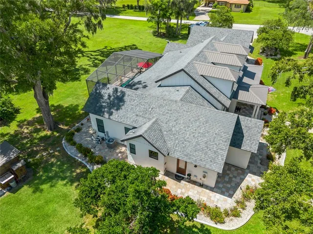 an aerial view of a house with a garden and lake view